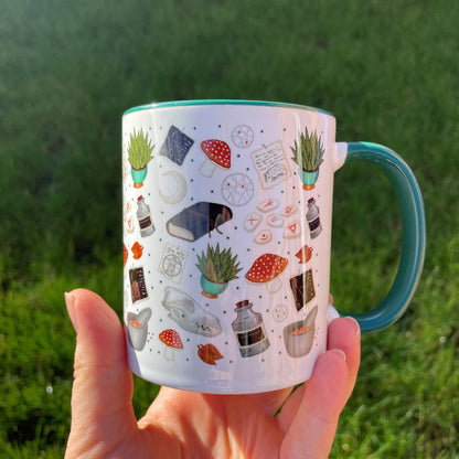 druid themed mug in green feature mushrooms, skulls, plants and runes in shades of greens and blues